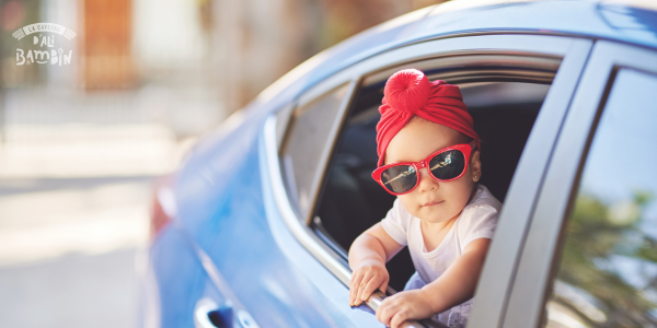 enfant cool par la fenêtre de la voiture au départ en vacances